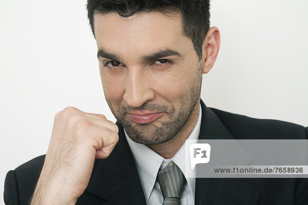Mid-adult businessman clenching fist  smiling