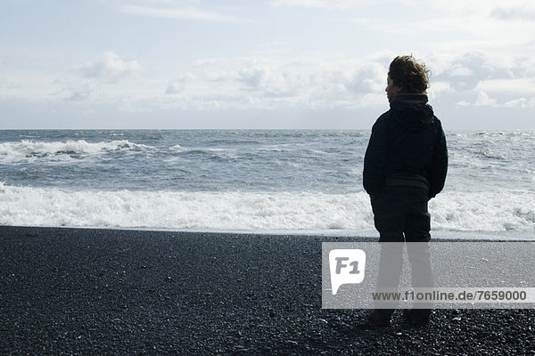 Junge mit Blick auf das Meer,  Island