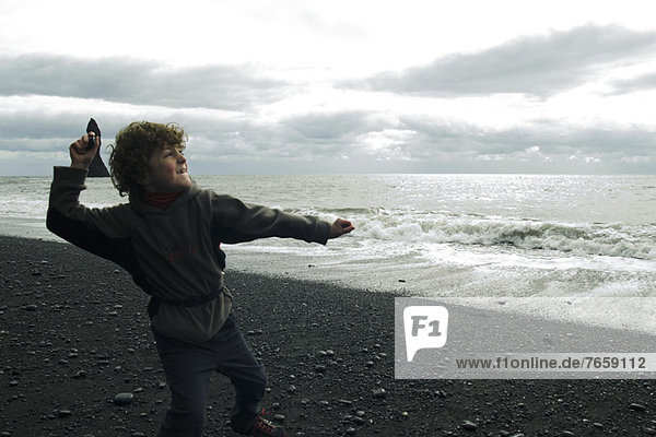 Junge  der am Strand abprallt Island