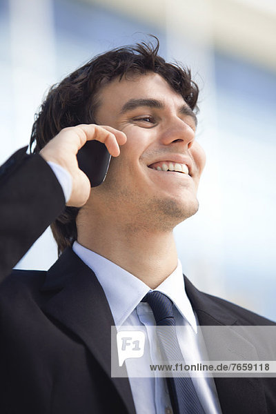 Young executive talking on cell phone  smiling