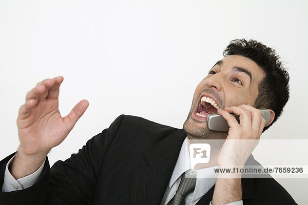 Geschäftsmann im mittleren Erwachsenenalter lacht laut  während er am Handy spricht