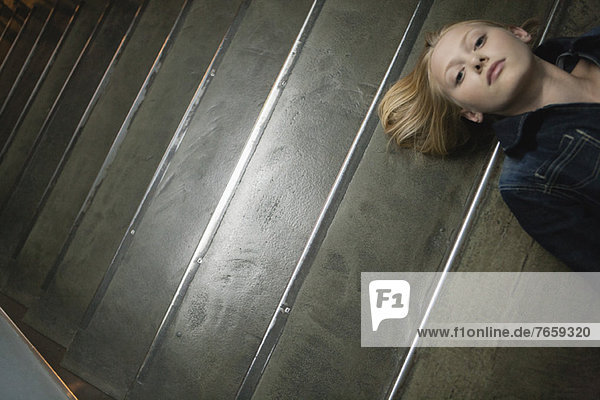 Young woman lying on stairs