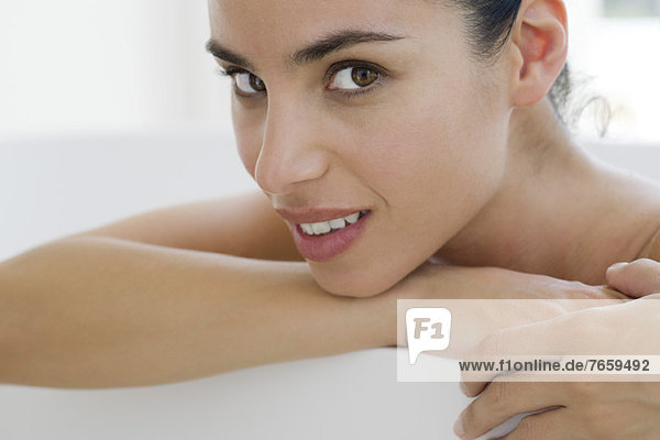 Woman in bath  resting head on arm  portrait