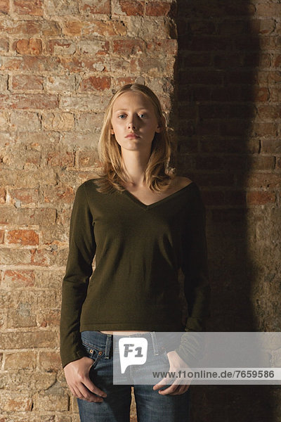Young woman standing with hands in pockets  portrait