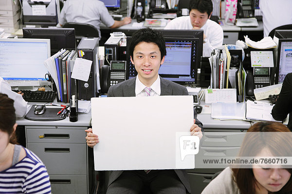 Businessman holding a white board in the office