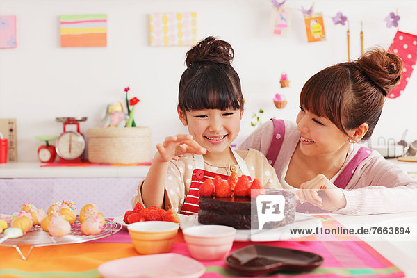 Mother and daughter making sweets in the kitchen