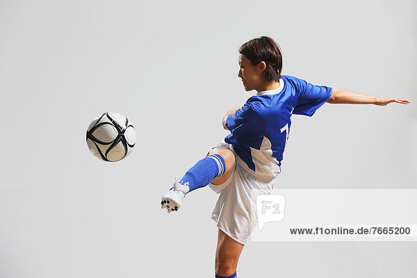 Woman In Soccer Uniform Practicing With Ball