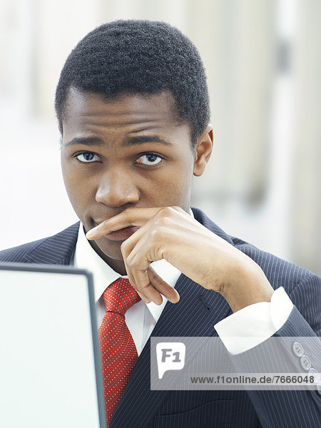 Businessman using a laptop in an office  serious  thoughtful