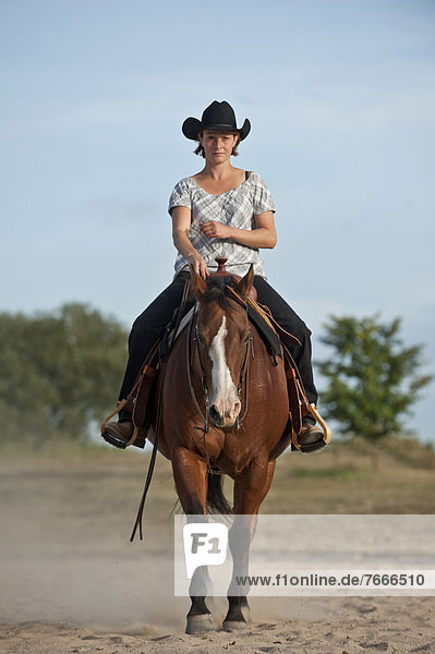 Woman riding a trotting Quarter Horse