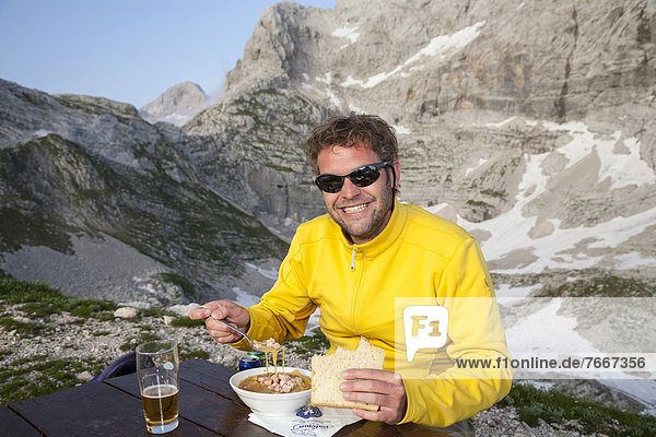 Wanderer beim Abendessen mit Jota  Sauerkrautsuppe  in der höchst gelegenen Berghütte  der Zasavska koca  im Sieben-Seen-Tal  Nationalpark Triglav  Slowenien  Europa