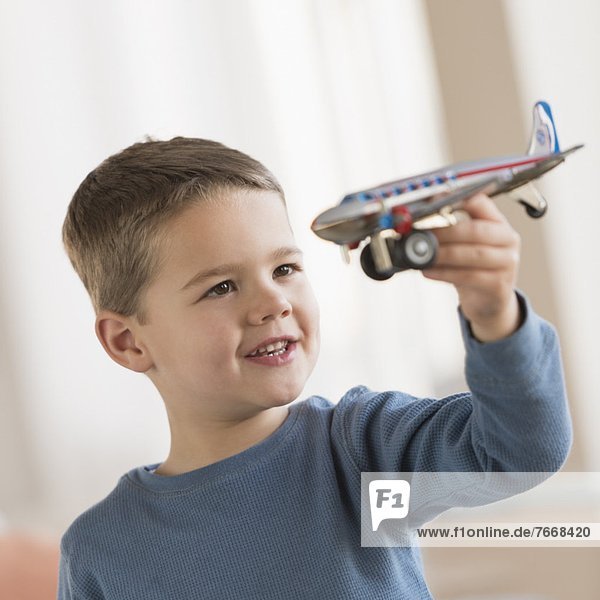 Boy (4-5) playing with toy plane