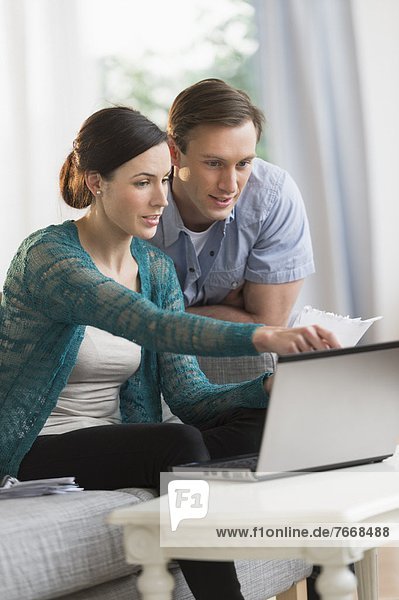Couple using laptop together to pay bills