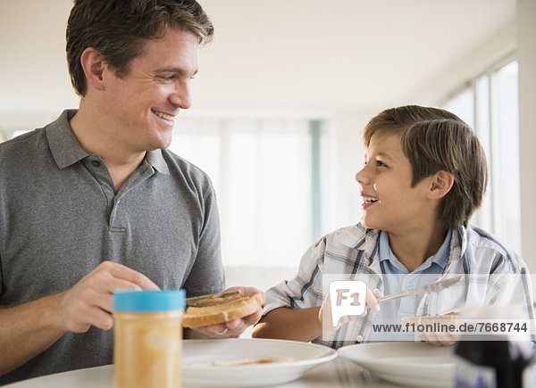 Menschlicher Vater  Sohn  5-9 Jahre  5 bis 9 Jahre  essen  essend  isst  Mittagessen
