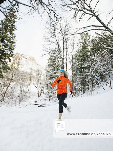 Woman jogging in winter forest