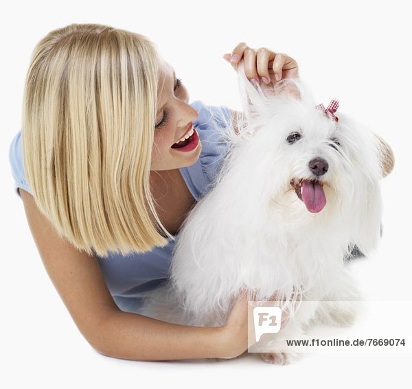 Studio Shot  Portrait of young woman stroking her dog