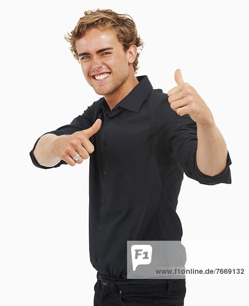 Studio Shot  Portrait of young man with thumbs up
