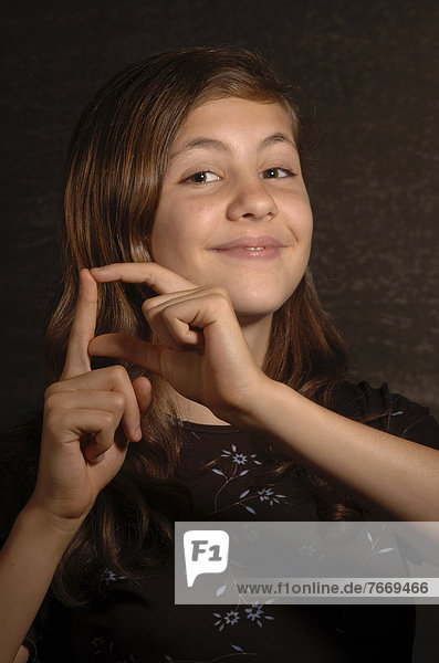 Smiling teenage girl making sign language