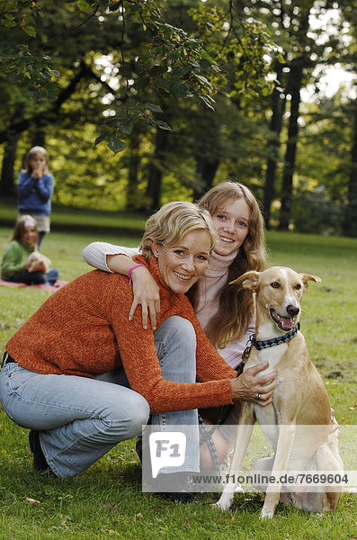 Mother and three daughters with a dog in a park