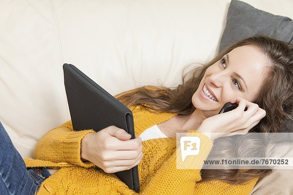 Handy  liegend  liegen  liegt  liegendes  liegender  liegende  daliegen  Frau  sprechen  Couch  Tablet PC