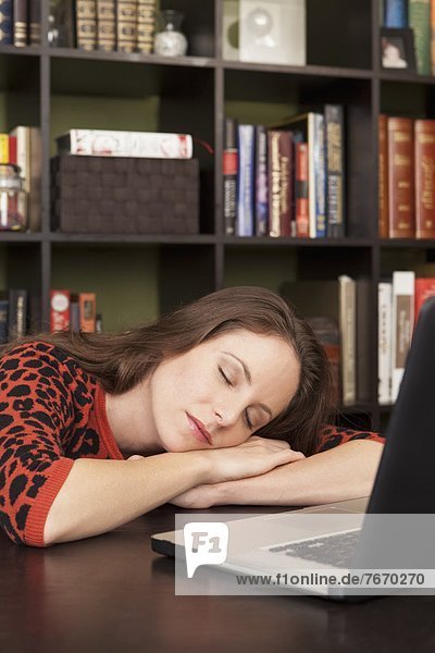 Woman sleeping next to laptop