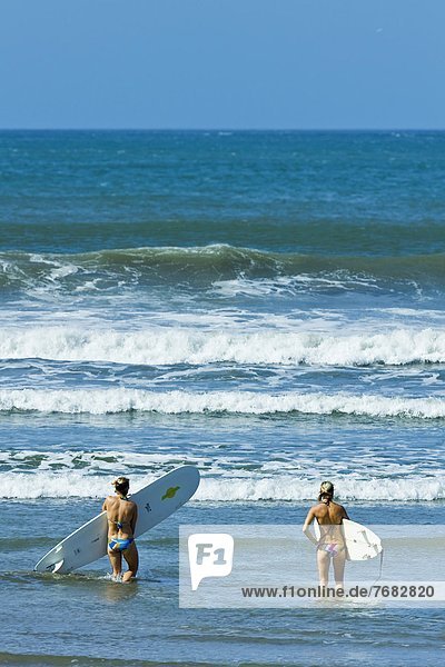 Girls surfing at popular Playa Guiones beach  Nosara  Nicoya Peninsula  Guanacaste Province  Costa Rica  Central America