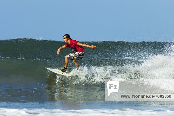 Surfer on shortboard riding wave at popular Playa Guiones surf beach  Nosara  Nicoya Peninsula  Guanacaste Province  Costa Rica  Central America