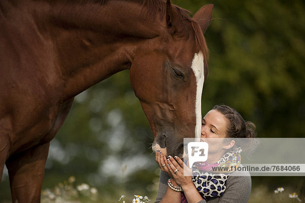 Woman kissing a Hanoverian horse