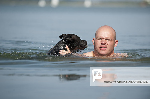 Mann Hund See schwimmen