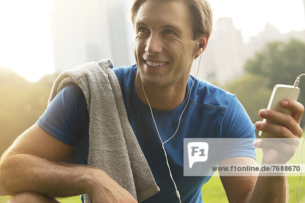 Man listening to mp3 player in park