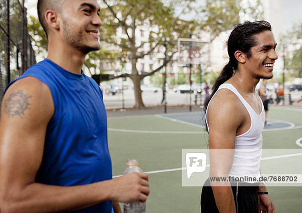 Männer lachen auf dem Basketballplatz