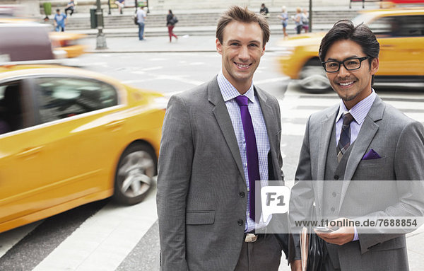 Businessmen smiling on city street