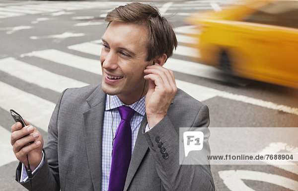Businessman talking on cell phone on city street
