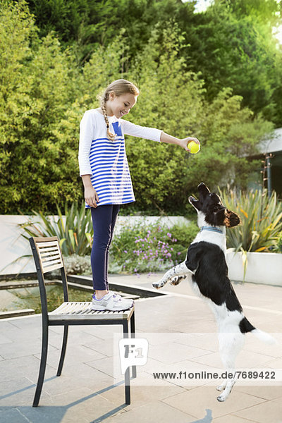 Mädchen spielt mit Hund im Freien