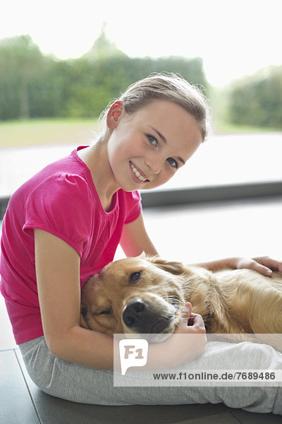 Mädchen entspannt mit Hund auf dem Boden
