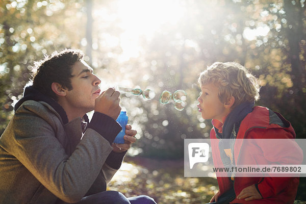 Vater und Sohn beim Blasenblasen im Park