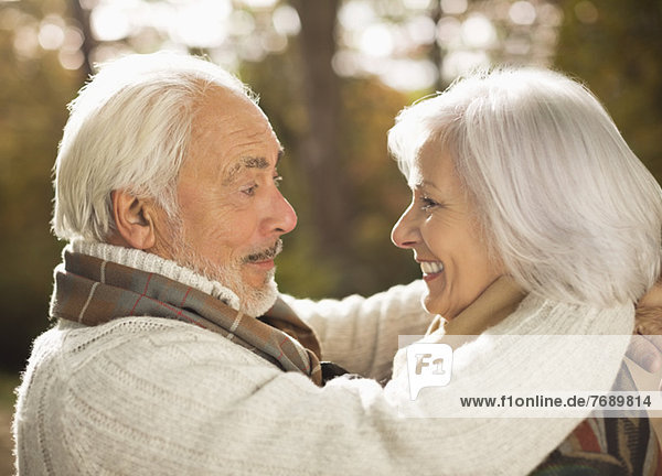 Older couple hugging outdoors