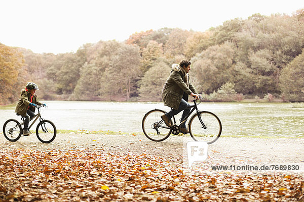 Father and son riding bicycles in park