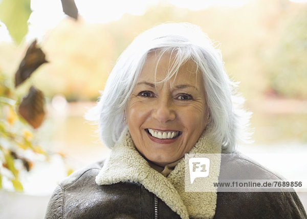 Lächelnde ältere Frau im Freien stehend