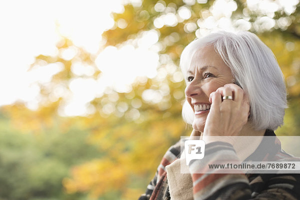 Ältere Frau beim Telefonieren im Park