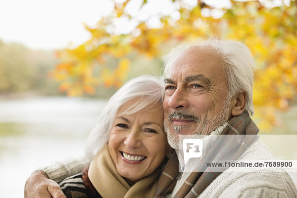 Older couple hugging in park