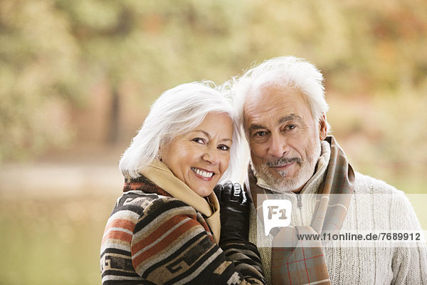 Older couple smiling together in park