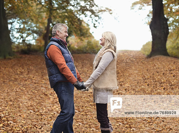 Älteres Paar hält sich im Park an den Händen