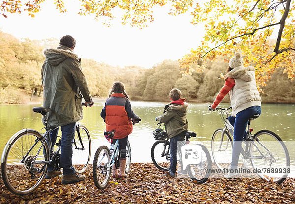 Family sitting on bicycles together in park