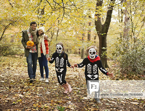 Children in skeleton costumes playing in park