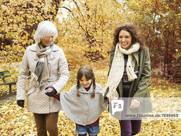 Three generations of women walking in park