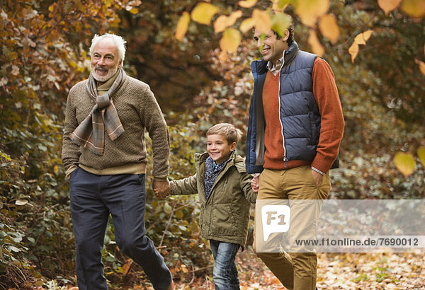 Three generations of men walking in park