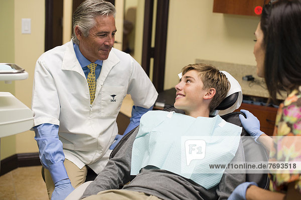 Dentist and nurse talking to patient