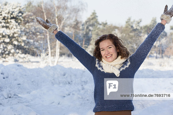Caucasian woman playing in snow