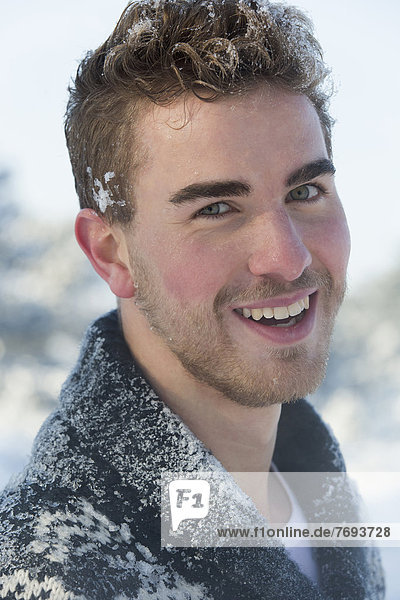 Caucasian man smiling in snow