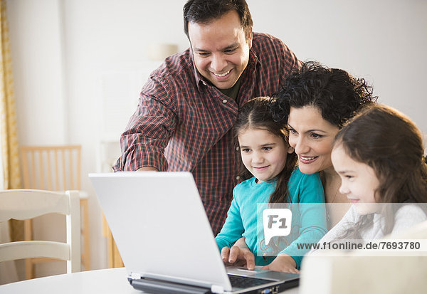 Family using laptop together at table